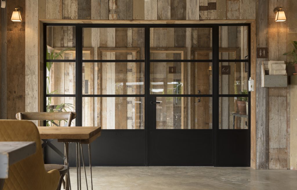 Internal back bifold doors in a room cladded with wood. 